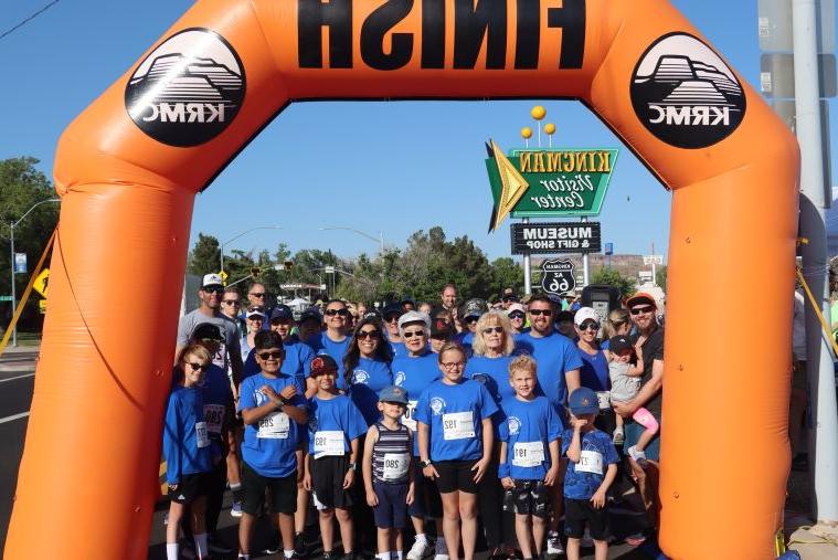 racers stand under an inflatable finish line arch